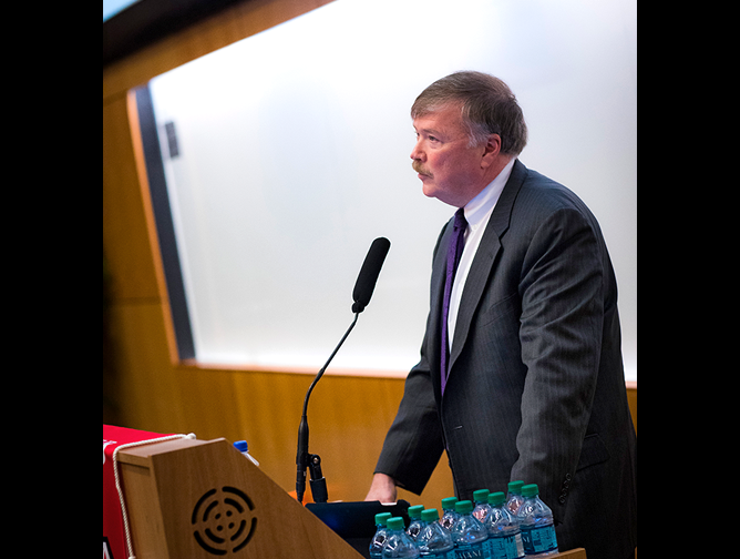 Professor John Farmer welcomes attendees to the symposium